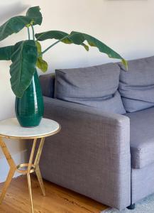 um vaso verde sentado numa mesa ao lado de um sofá em Beautiful Apartment Bairro Alto - River view em Lisboa