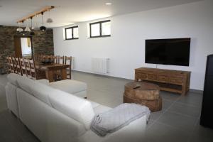 un soggiorno con divano bianco e TV a schermo piatto di Casa da Teresinha a Bragança