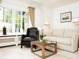 een woonkamer met een bank en een stoel bij Hummelhüs von Appartements & Mehr in Kampen