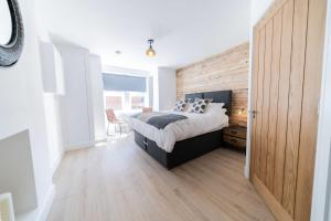 a bedroom with a bed and a wooden wall at 2 Ashbrook Windmill in Oxford