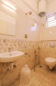 a bathroom with a sink and a toilet at THE MARELLA SUITES in Bangalore