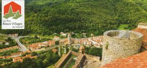 uma vista para uma cidade com uma placa e um castelo em Serra-Vernet del Roser em Prats-de-Mollo-la-Preste