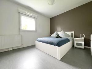 a bedroom with a bed with blue sheets and a window at Le Joséphine in Nantes