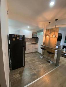 eine Küche mit einem schwarzen Kühlschrank und einem Tisch in der Unterkunft Impecable y lujoso apartamento para una estadía unica in Medellín