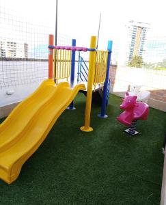 um parque infantil com um escorrega amarelo e um porco de brinquedo em Impecable y lujoso apartamento para una estadía unica em Medellín