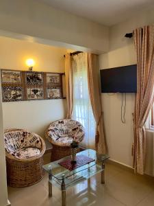 a living room with two chairs and a glass table at Sunset Hotel Entebbe in Entebbe