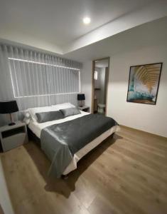 een slaapkamer met een groot bed en een houten vloer bij Impecable y lujoso apartamento para una estadía unica in Medellín