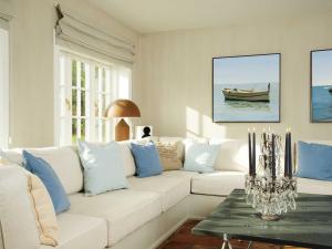 - un salon avec un canapé blanc et des oreillers bleus dans l'établissement Inselhaus von Appartements & Mehr, à Kampen