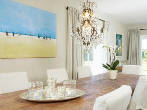 une table à manger avec des chaises blanches et un lustre dans l'établissement Inselhaus von Appartements & Mehr, à Kampen