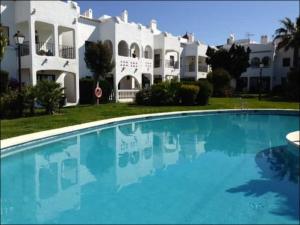 une grande piscine en face d'une grande maison dans l'établissement Townhouse Estepona, à Estepona