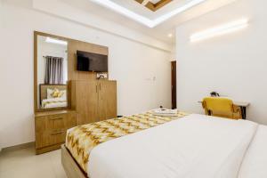 a bedroom with a bed and a television in it at THE MARELLA SUITES in Bangalore