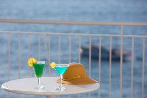 a hat and two cocktails sitting on a table at Hotel Piccolo Paradiso in Massa Lubrense