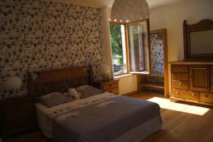 una camera da letto con un letto con un orsacchiotto sopra di La Maison de Rochebois, chambres et table d'hôtes, Savoie, France a Champagneux