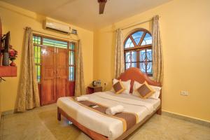 a bedroom with a large bed with a window at Oceanside Beach House-By Roseal in Baga