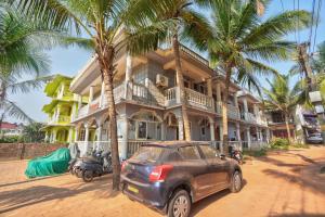 um carro estacionado em frente a uma casa com palmeiras em Oceanside Beach House-By Roseal em Baga