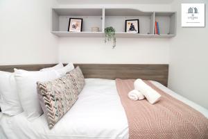 a bedroom with a bed with white sheets and pillows at Modern 2 Bed Apartment - Near City Centre - By EKLIVING LUXE in Cardiff