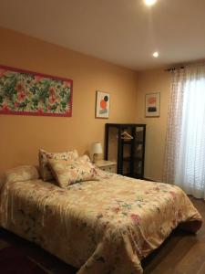 1 dormitorio con 1 cama y una pintura en la pared en Las Violetas, en Villanueva de los Infantes