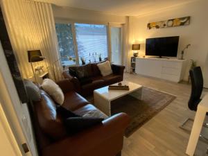 een woonkamer met 2 banken en een televisie bij Ferienwohnung KatzenTraum in Bad Harzburg