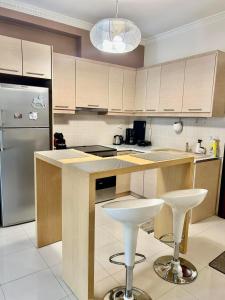 a kitchen with a counter and two bar stools at CYNTHIA COMFORT LIVING VOLOS in Volos
