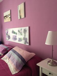 1 dormitorio con paredes moradas y 1 cama con lámpara en Las Violetas, en Villanueva de los Infantes