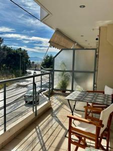a balcony with a table and chairs and a car at CYNTHIA COMFORT LIVING VOLOS in Volos