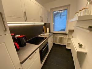 een keuken met witte kasten en een kookplaat oven bij Ferienwohnung KatzenTraum in Bad Harzburg