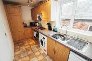 La cuisine est équipée d'un évier et d'un lave-vaisselle. dans l'établissement Cottages In Derbyshire, Oak Cottage, à Hazelwood