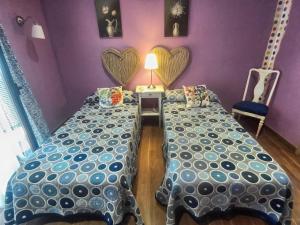 twee bedden in een slaapkamer met harten aan de muur bij Las Violetas in Villanueva de los Infantes