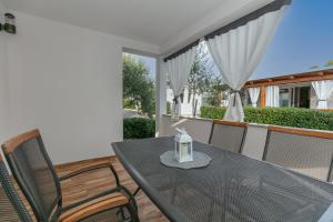 a table and chairs on a balcony with a lantern at Camp Lana in Drage