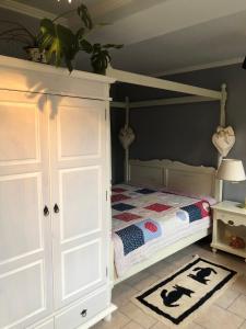 a bedroom with a bed and a white cabinet at Little Cottage auf 2 Etagen in Raben Steinfeld