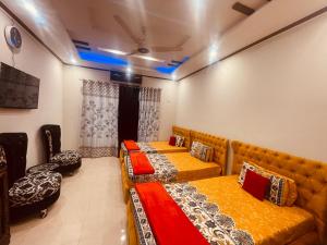 two beds in a room with blue lights at Britannia House near Islamabad International Airport and Motorway in Islamabad
