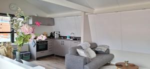 a living room with a couch and a kitchen at Have a nice stay! - De Pottenbakkerij in Noordwijk
