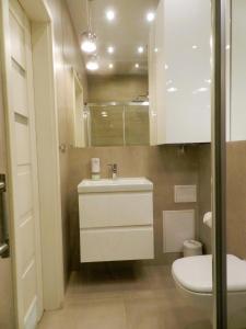 La salle de bains est pourvue d'un lavabo et de toilettes. dans l'établissement Apartament Donnka, à Cracovie