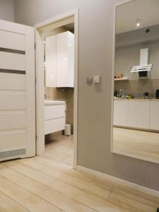 a kitchen with white cabinets and a mirror at Apartament Donnka in Krakow