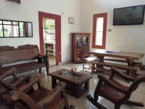 uma sala de estar com mobiliário em madeira e uma televisão de ecrã plano em Finca la sharola em Guaduala