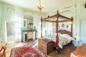 sypialnia z łóżkiem z baldachimem i kominkiem w obiekcie Les Louteaux - Splendide Château du XVIII -Piscine- Parc de Lamas w mieście Chézy +37 zdjęć