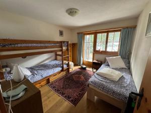 a room with two bunk beds and a desk at Chalet Alten in Klosters Dorf