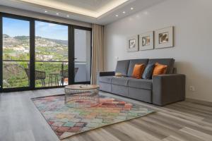 una sala de estar con un sofá y una mesa en Torre Palace II by Atlantic Holiday, en Câmara de Lobos