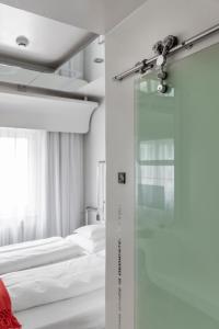 um quarto com duas camas e uma porta de vidro em Hotel Aurora em Merano