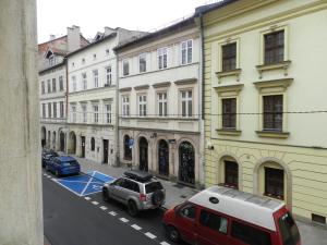 una calle de la ciudad con coches estacionados frente a los edificios en Apartament Donnka, en Cracovia