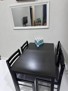einem schwarzen Tisch mit einem schwarzen Stuhl vor einem Spiegel in der Unterkunft WAJA HOMESTAY in Kampong Pengkalan Nyireh