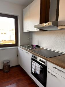 cocina con fogones, fregadero y ventana en Hotel Rennekamp en Oyten
