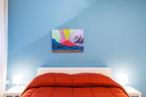 um quarto com uma cama com um quadro na parede em Amedeo Comfort Apartment at Chiaia by Napoliapartments em Nápoles