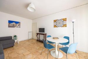uma sala de estar com uma mesa e cadeiras e um sofá em Amedeo Comfort Apartment at Chiaia by Napoliapartments em Nápoles