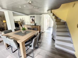 une salle à manger avec une table et un escalier dans l'établissement Le Doux Refuge de Bouillon, à Corbion