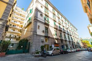 um edifício alto com carros estacionados em frente em Amedeo Comfort Apartment at Chiaia by Napoliapartments em Nápoles