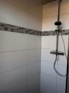 a bathroom with a shower with white tiles at Hotel Rennekamp in Oyten