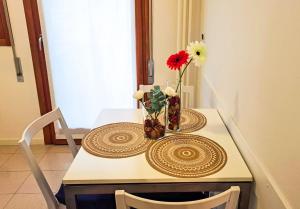 einen Tisch mit einer Blumenvase drauf in der Unterkunft QUEEN HOME GEMMA in Mestre