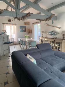 a living room with a blue couch and a table at Maison de vacances : Bord de mer in Saint-Pierre-dʼOléron