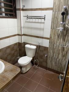 a bathroom with a toilet and a shower at Frosty Hills Homestay in Tanah Rata